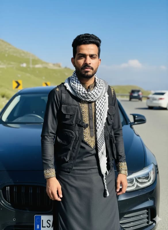 Confident Man in Traditional Afghan Clothing on Mountain Road thumbnail 2